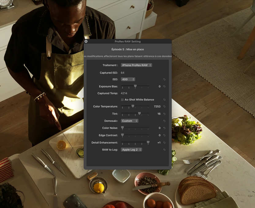 Écran d’iPhone 17 Pro montant les flux de travail pros pour une vidéo, une personne se tient devant un comptoir de cuisine et coupe des légumes