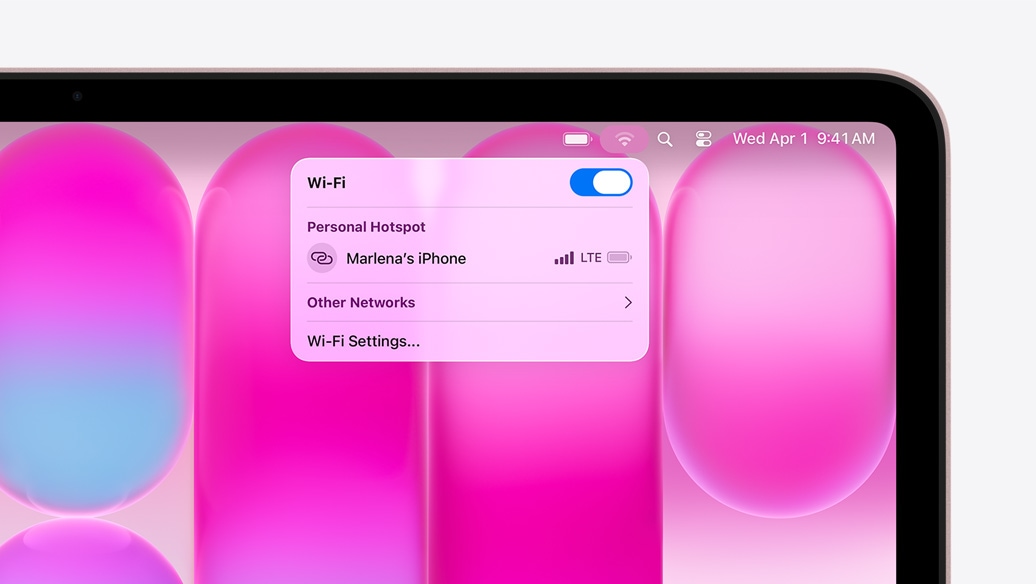 MacBook Neo, σε χρώμα αιθέριο ροζ, το μενού Wi‑Fi εμφανίζει την ενότητα Προσωπικό Hotspot με την επιλογή "Marlena's iPhone"