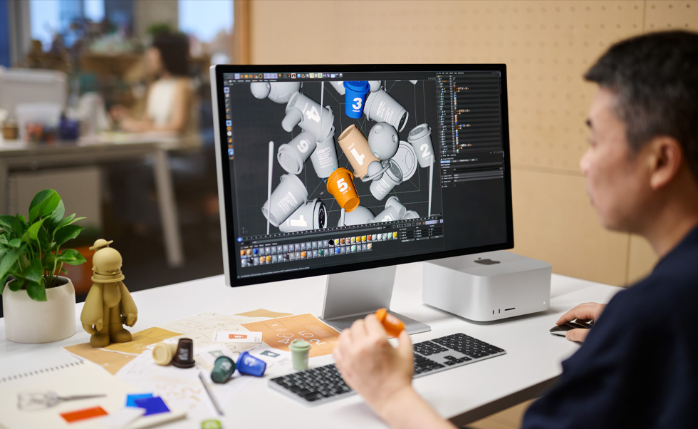 Um designer usa o Mac para renderizar um projeto 3D.
