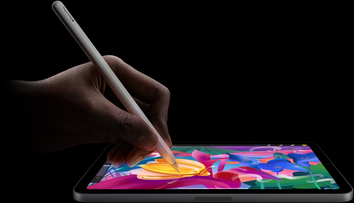 En brugers hånd, der holder Apple Pencil Pro og skaber farverig kunst på iPad mini.